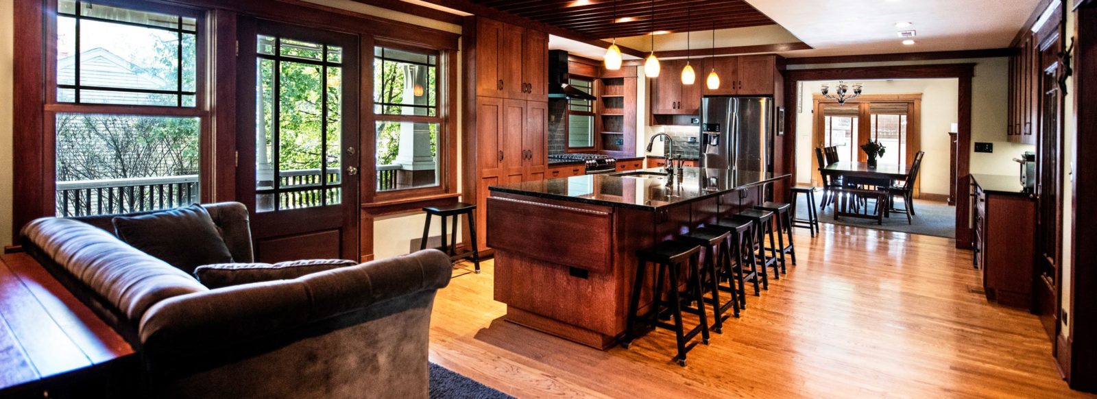 kitchen with dark cabinets and island with black countertop with 4 pendant lights
