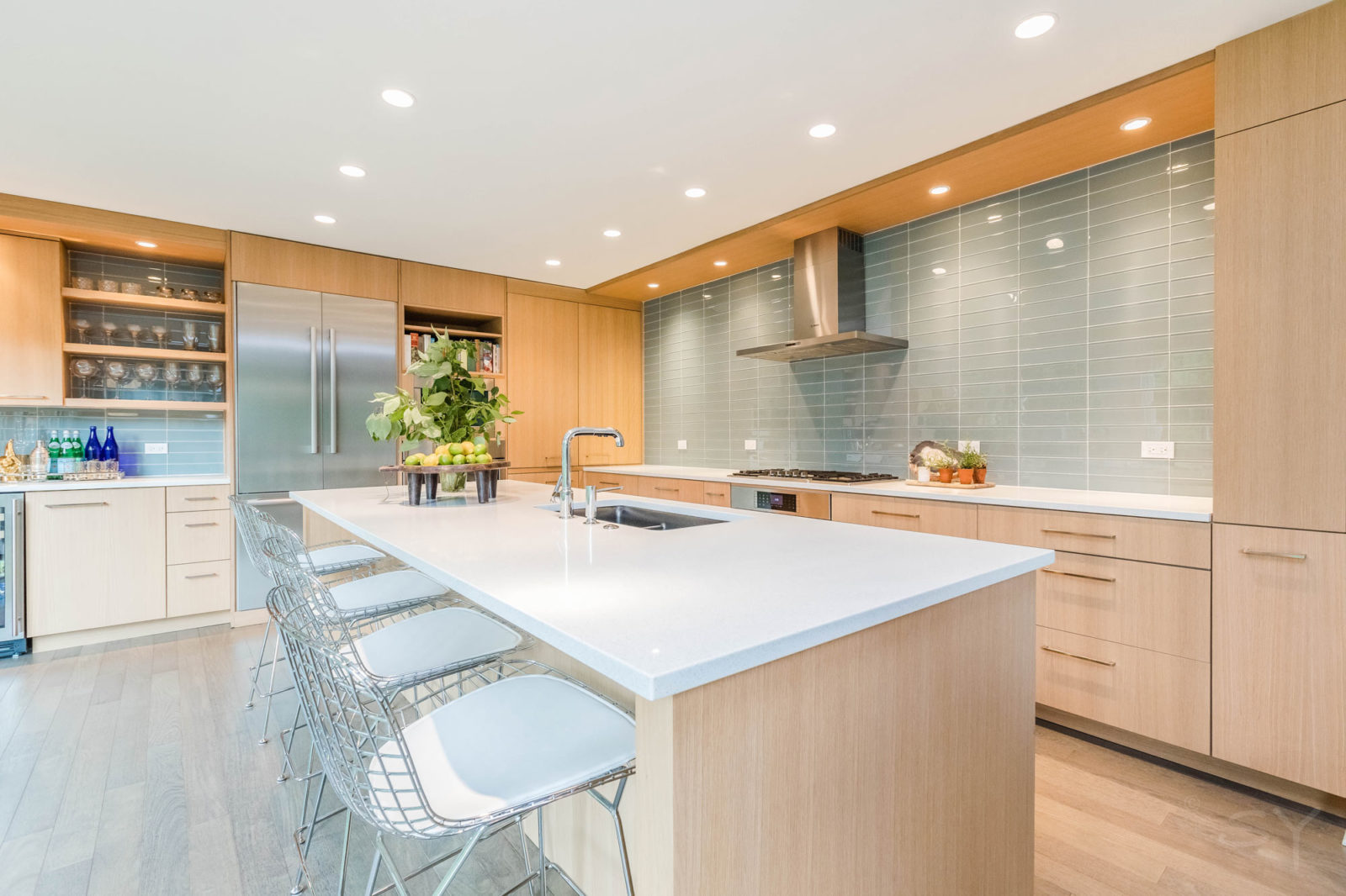 LivCo kitchen remodel large white island with bar seating recess lighting subway tile backsplash