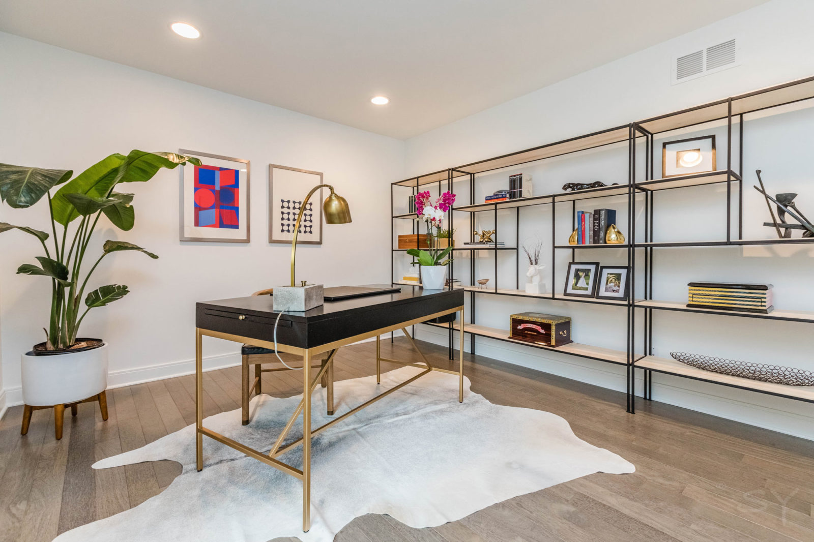 livco home office design black and gold desk over cowhide rug beside open shelving unit