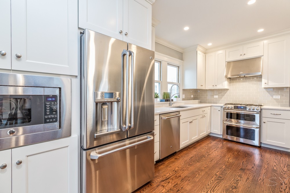 kitchen renovation white cabinetry chrome finishes stainless steel appliances hardwood flooring