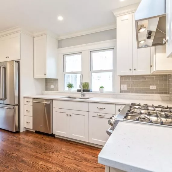 bright airy kitchen white cabinets and countertops stainless steel appliances hardwood floors