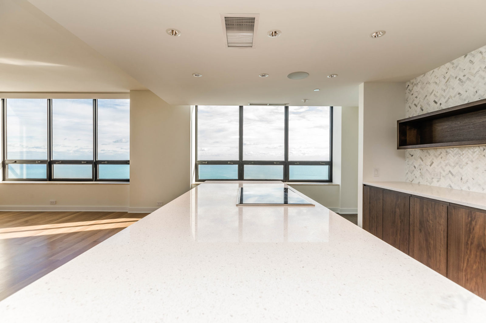 LivCo high rise kitchen remodel large white quartz island patterned backsplash large windows
