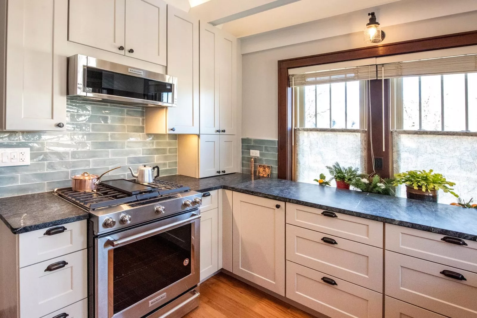 kitchen renovation white cabinetry dark granite coutnertops stainless steel light blue blacksplash