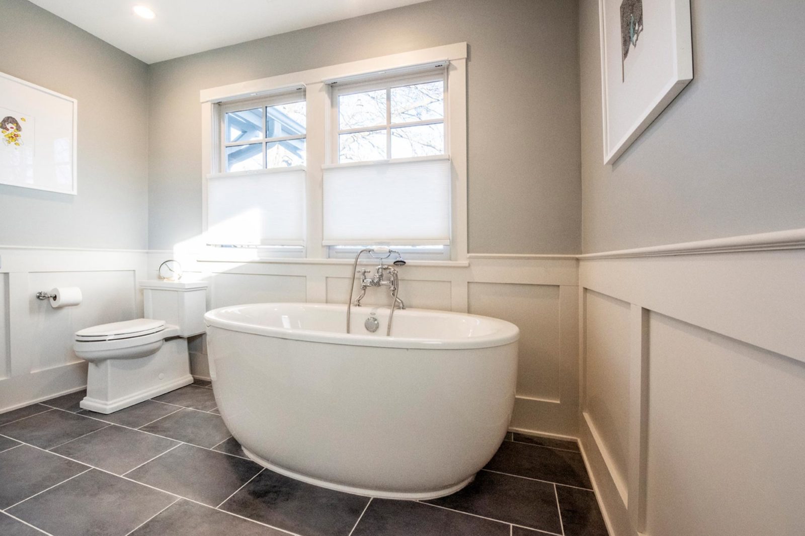 bathroom renovation stand aloone white garden tub white wainscoating grey walls grey tile floors