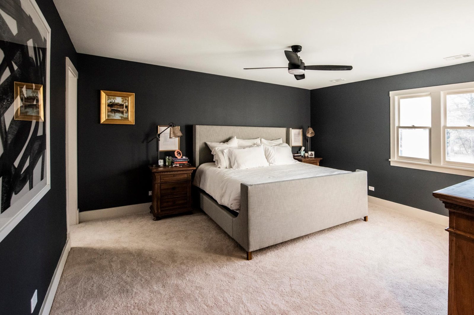Updated bedroom with dark walls & light-toned bed linens, bedframe, & carpet