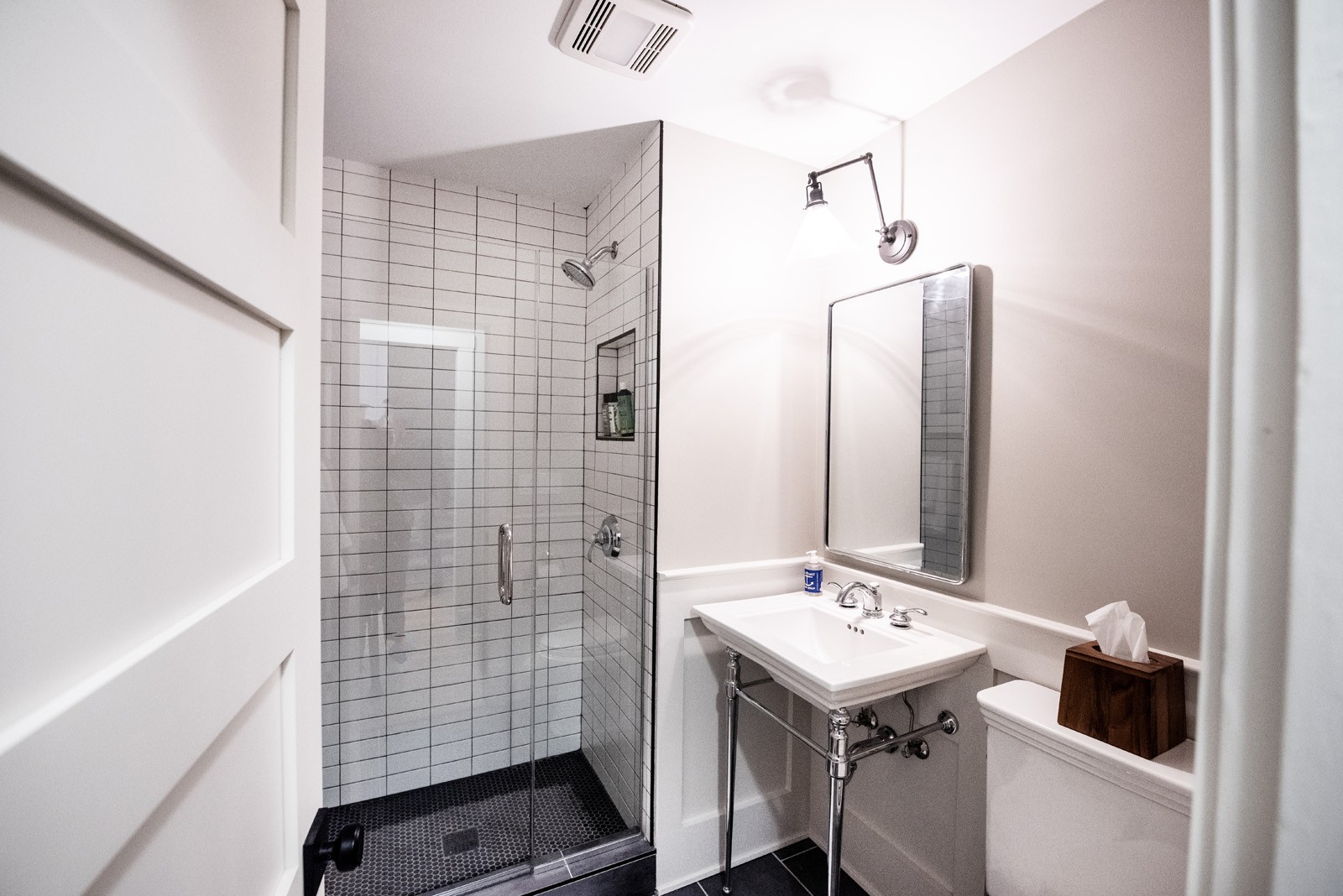 clean bathroom shower with glass door & subway tiles chrome finishes small mirror over open vanity