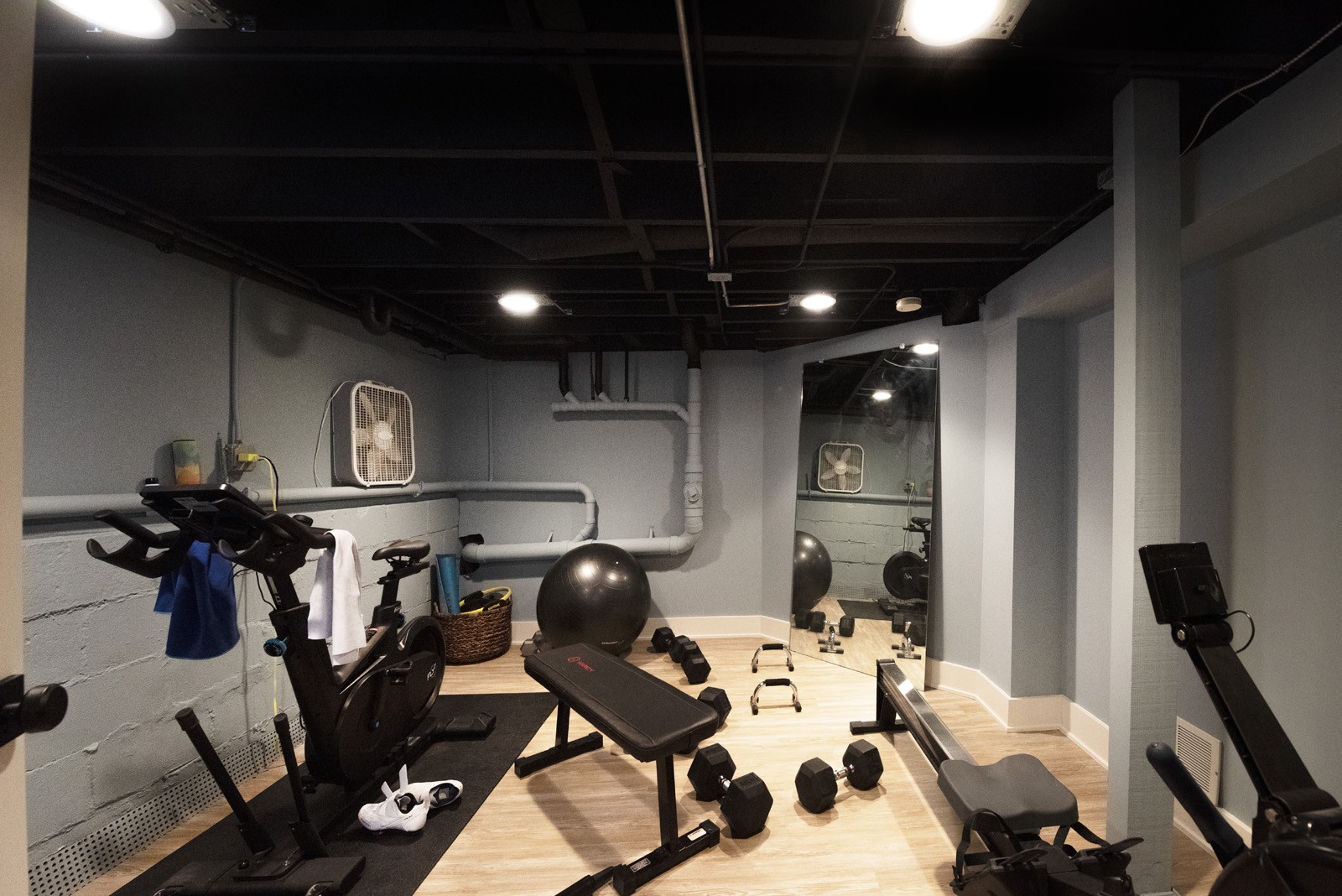 Home gym with workout equipment, mirror, and grey walls
