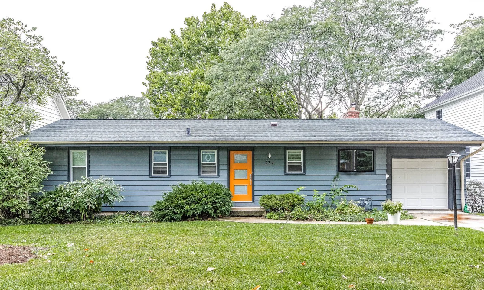 mid century modern ranch renovation and remodel view of exterior painted grey with orange front door