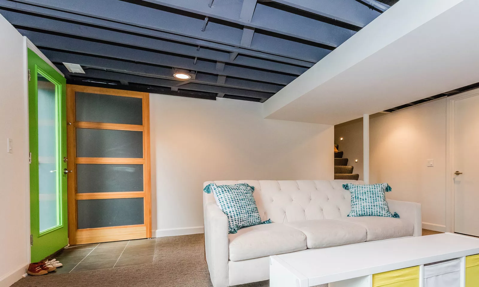 mid century modern ranch renovation and remodel view of finished basement with black painted exposed ceiling joists