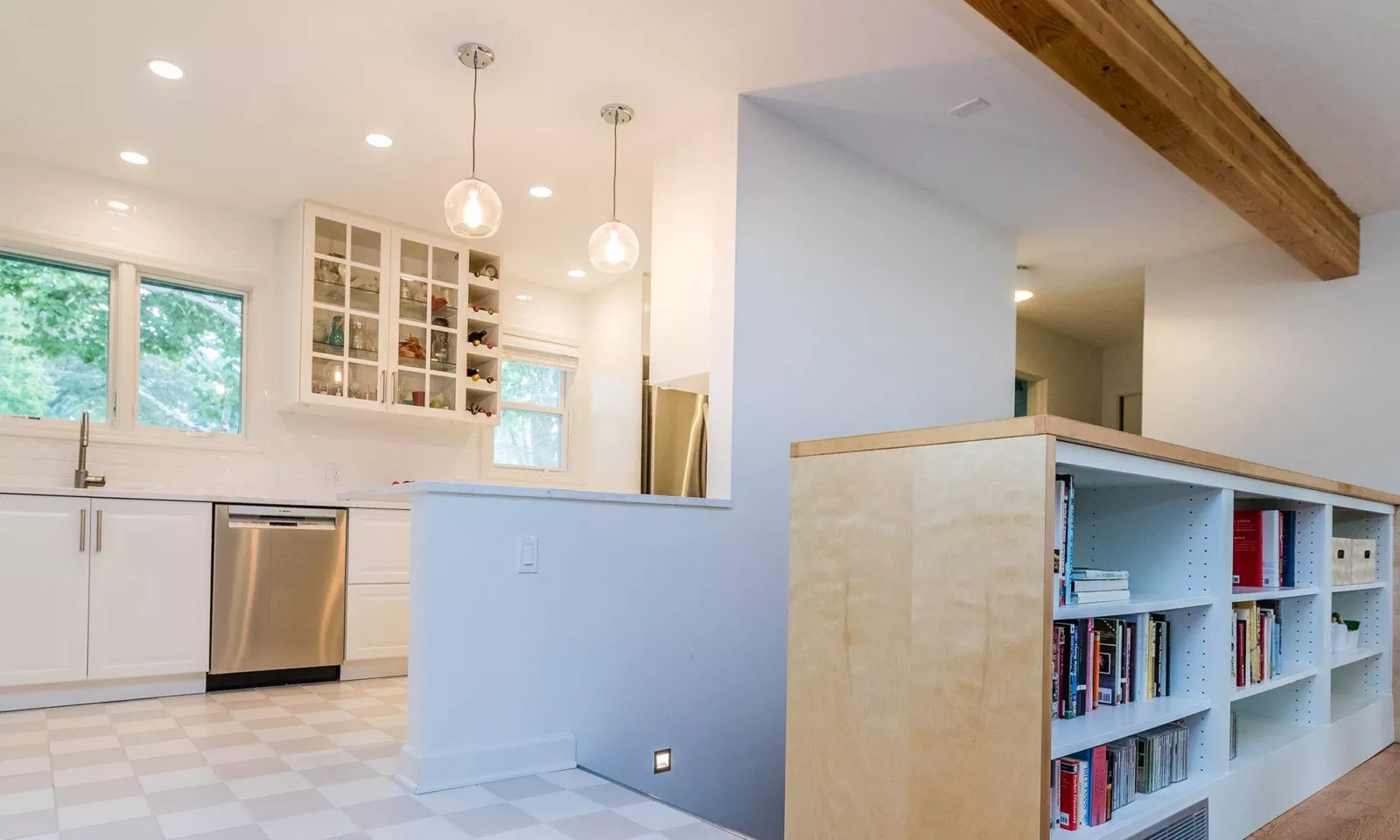 mid century modern ranch renovation and remodel view of stairs down to basement with white kitchen beyond