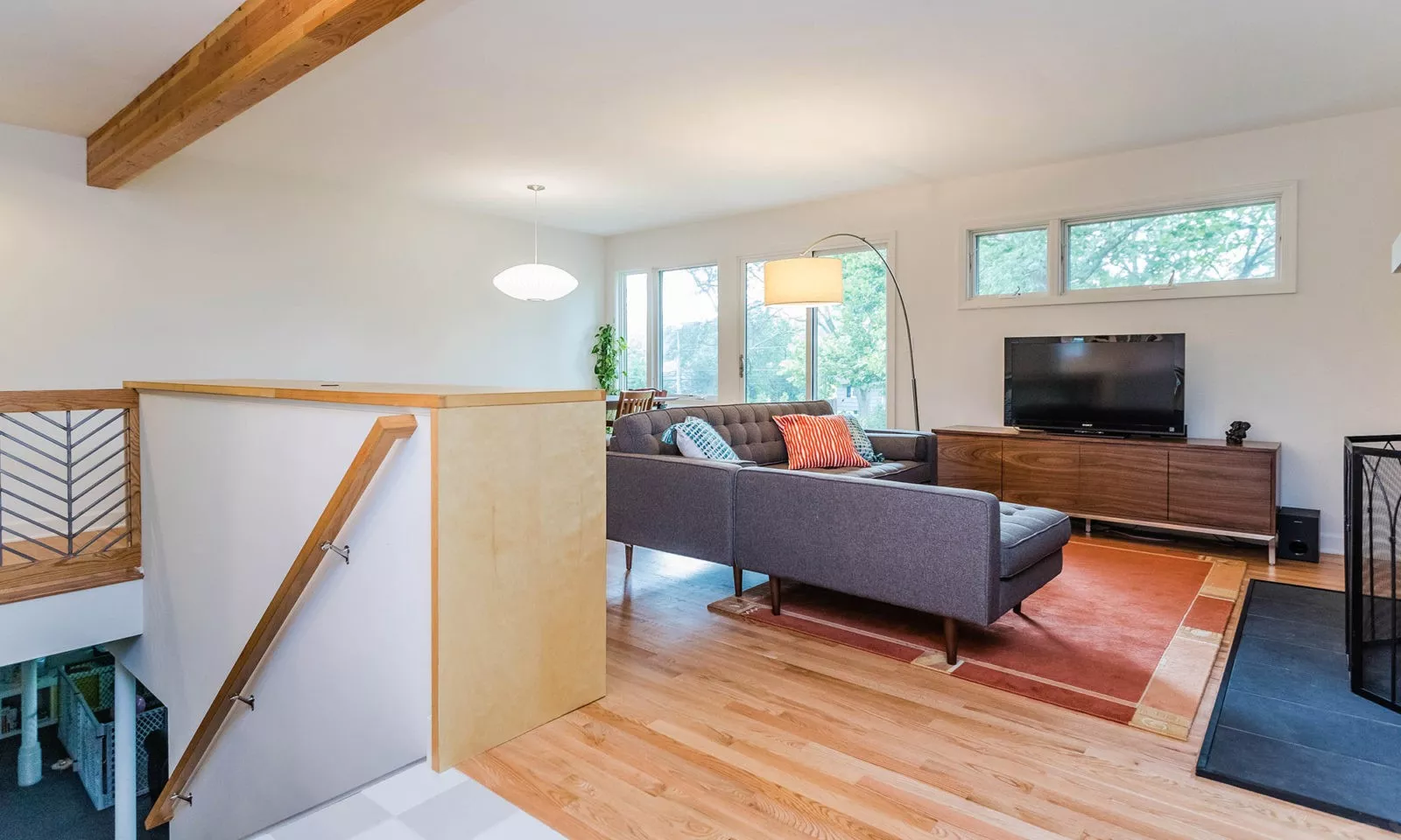 mid century modern ranch renovation and remodel view of stair down to basement with family room beyond