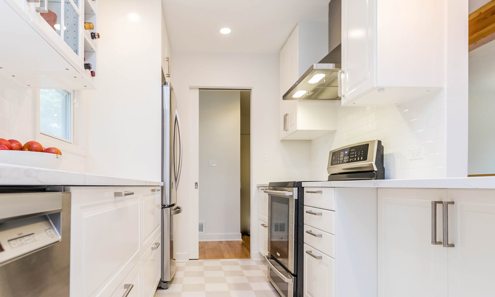 mid century modern ranch renovation and remodel view of white kithcen with stainless steel appliances range and hood