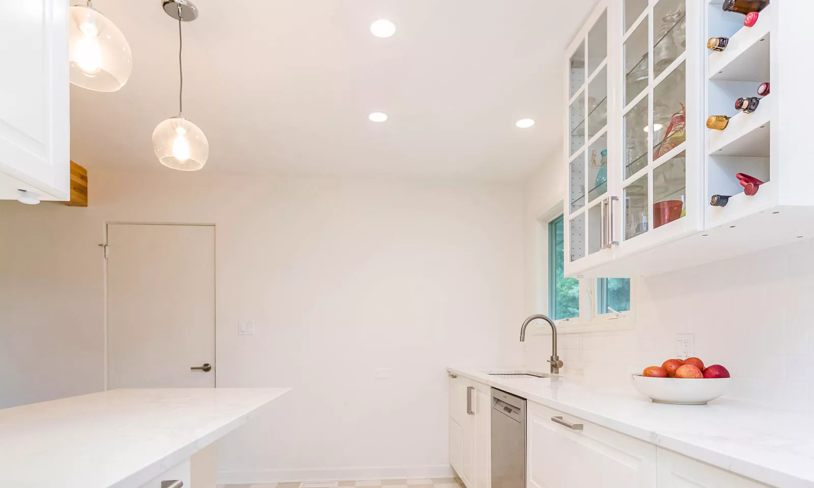 mid century modern ranch renovation and remodel view of white kithcen with stainless steel appliances range and hood