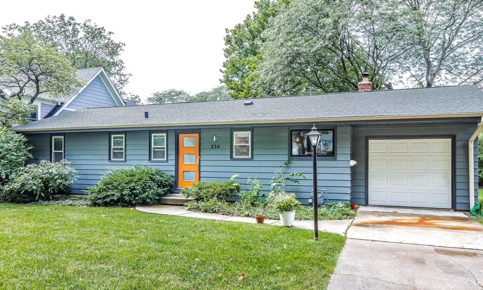 mid century modern ranch renovation and remodel view of exterior painted grey with orange front door