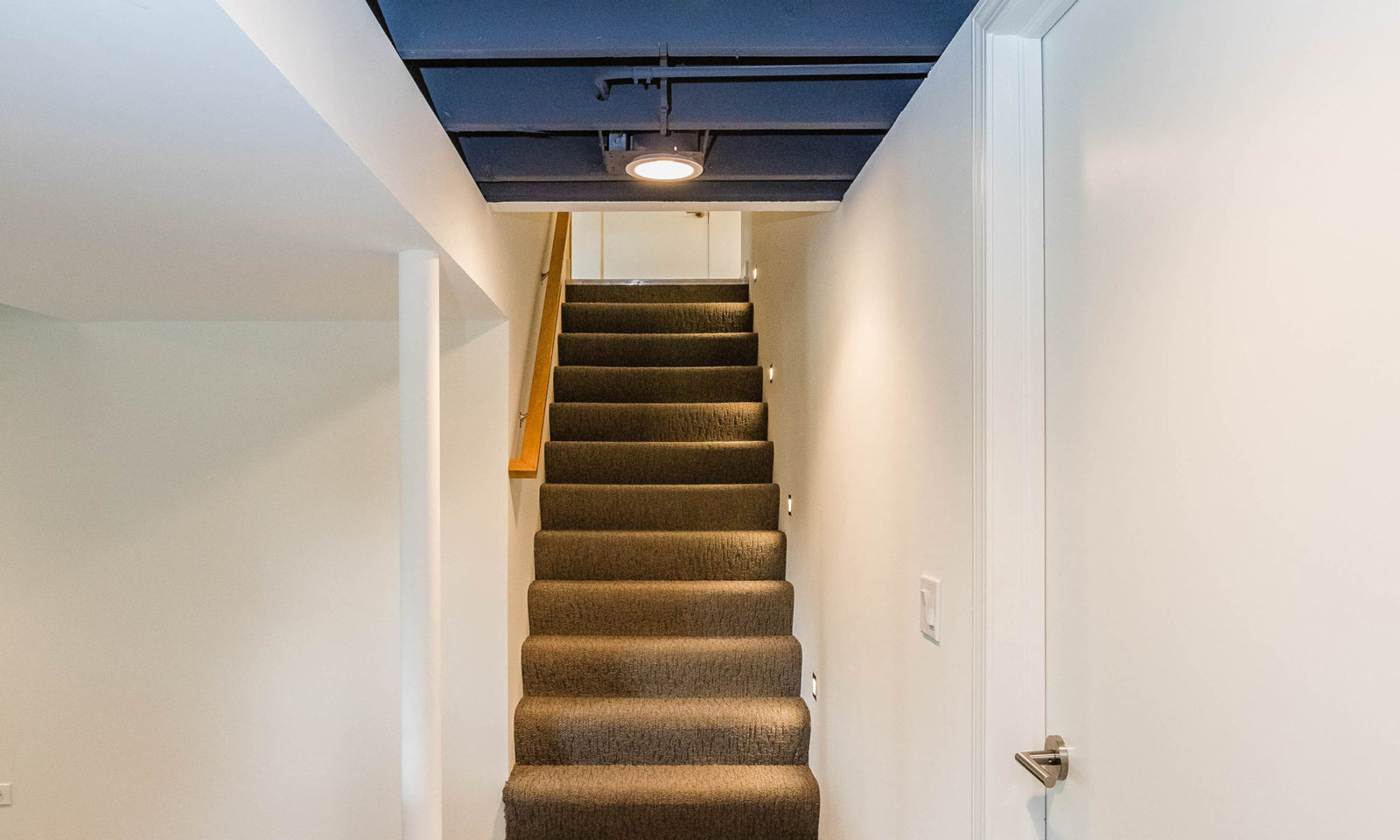 mid century modern ranch renovation and remodel view of carpeted and lighted stairs from basement