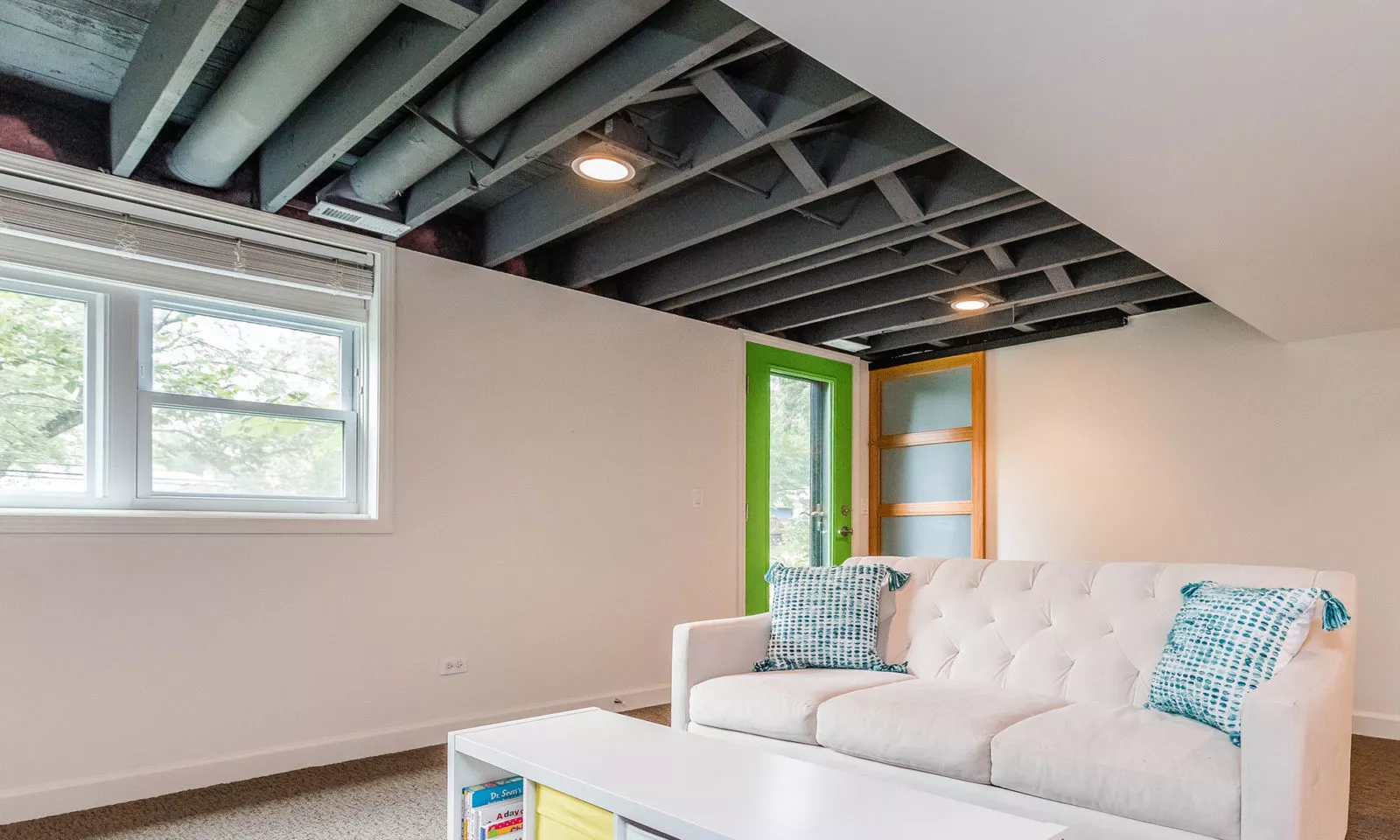 mid century modern ranch renovation and remodel view of finished basement with black painted exposed ceiling joists