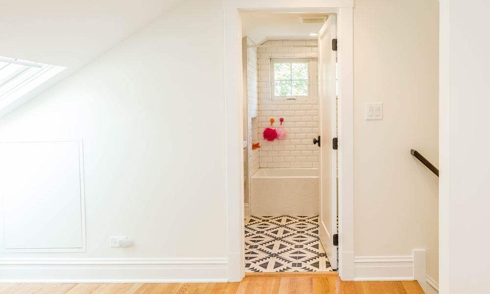 view into a bathroom with patterned black and white concrete tile