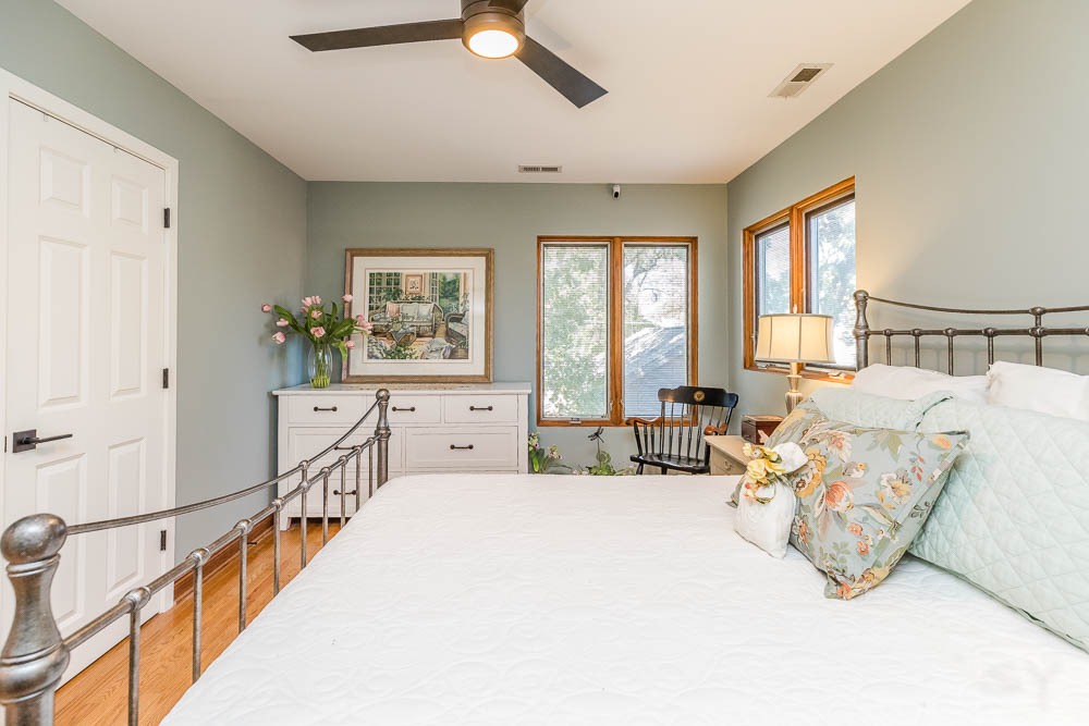 LivCo bedroom design vintage farmhouse grey brass bed hardwood floors nuetral green paint
