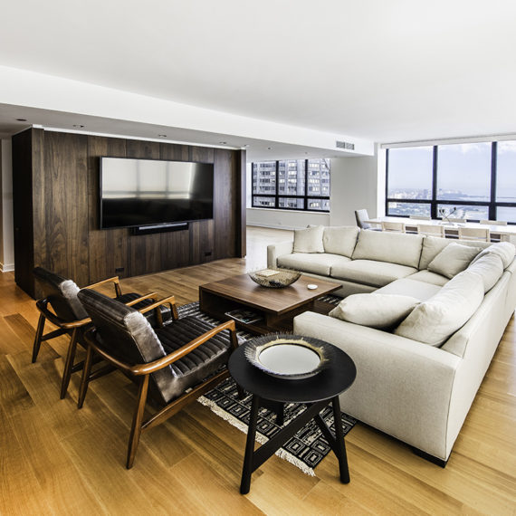 Newly renovated living room with large bright windows, recessed windows, wood floors, and wood walls