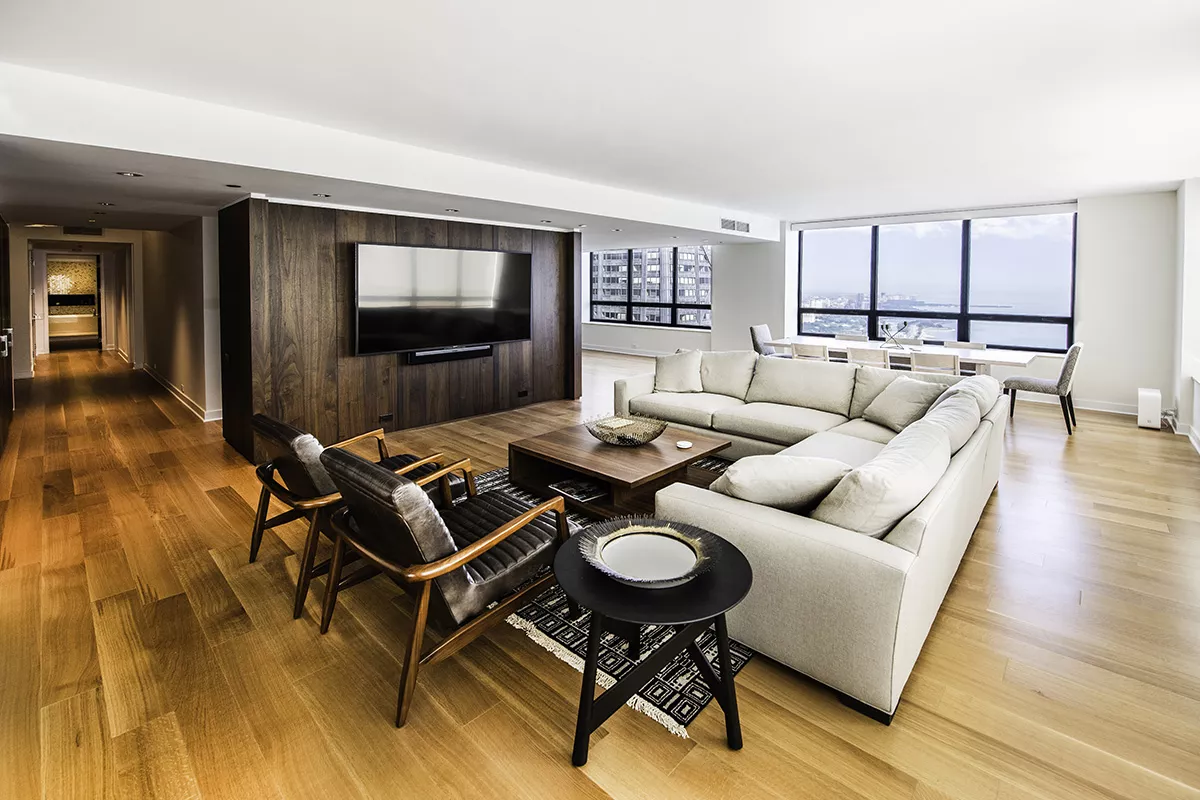 Newly renovated living room with large bright windows, recessed windows, wood floors, and wood walls