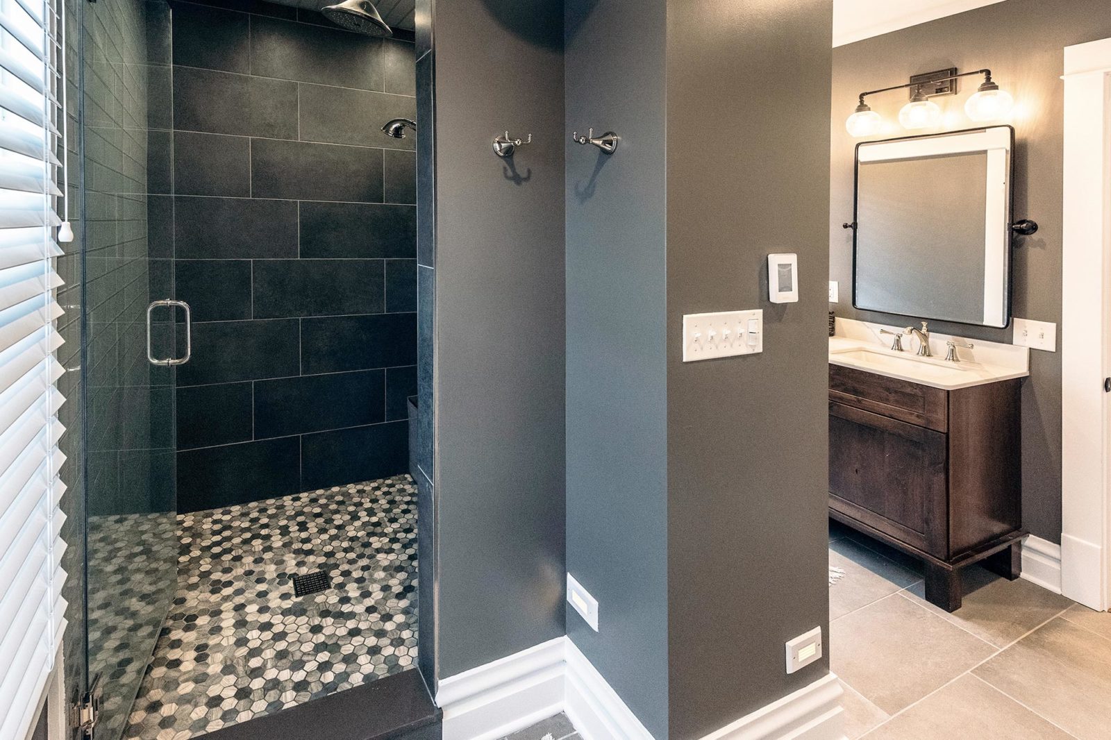 LivCo bathroom renovation glass shower grey walls black tile vintage vanity