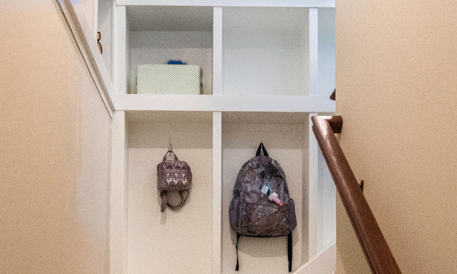 view of mudroom builtins along stair with hooks for backpacks