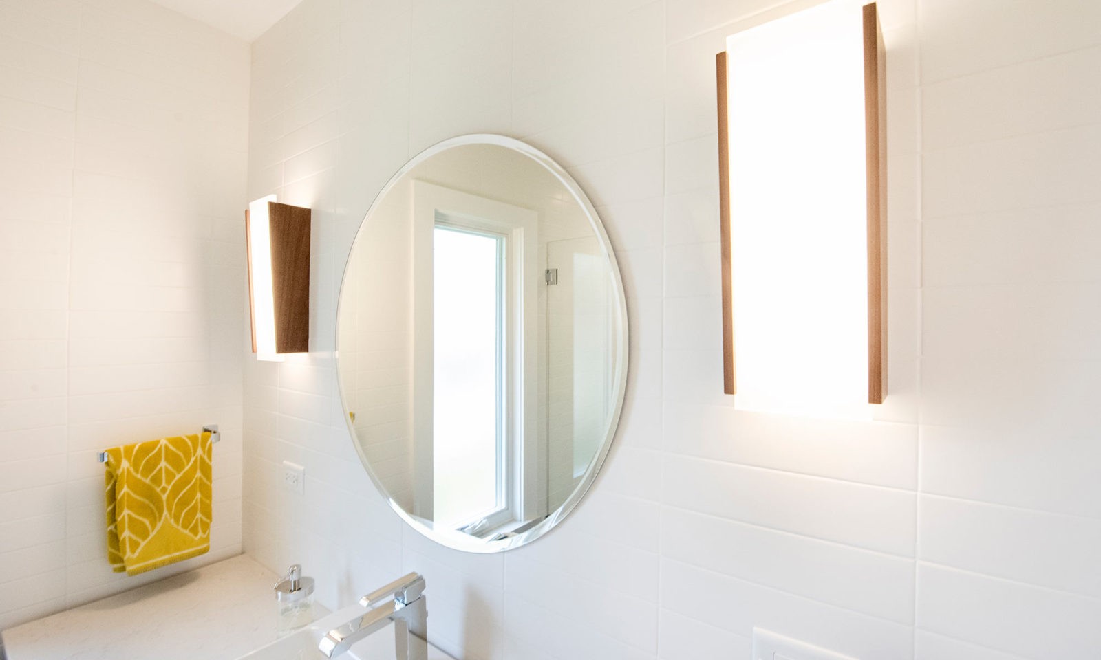 Riverside Illinois bathroom remodel round mirror and wood sconces