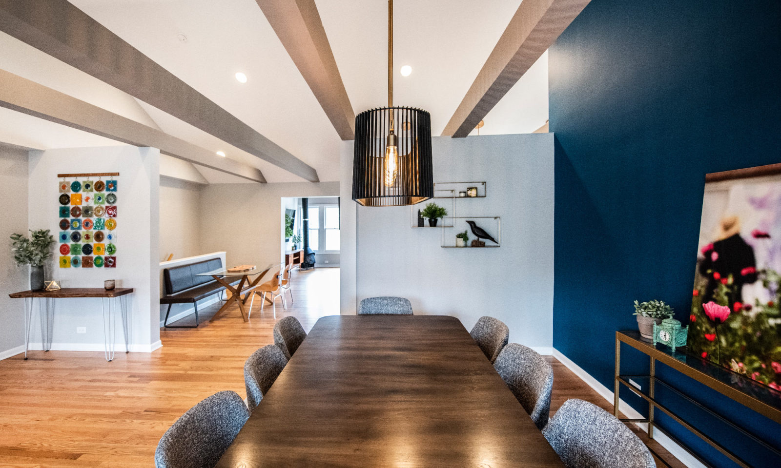 Dining room with table & chairs, connected to a hallway with a sitting space & living room