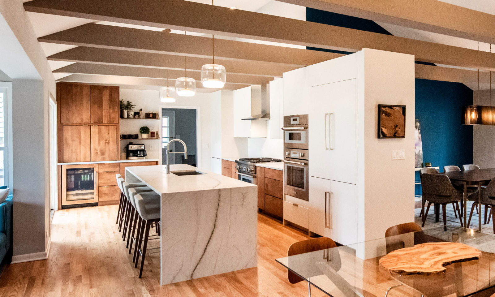 whole home remodel kitchen view waterfall island with 5 barstools white cabinetry hardwood floor