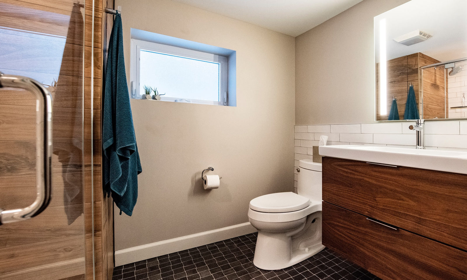 view of new basement bathroom with dark greay floors and walnut vanity