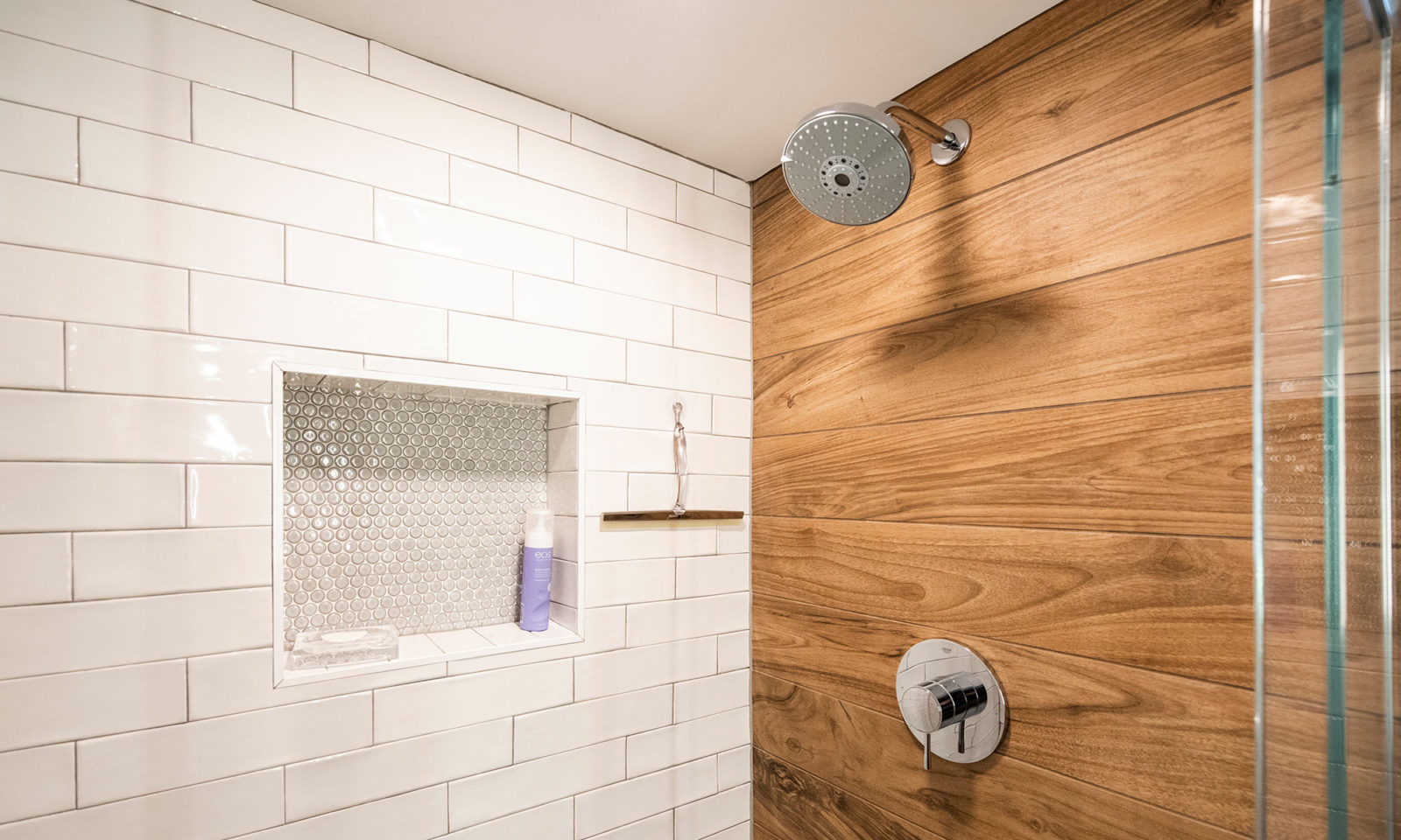 view of shower with white subway tile and wood looking tile