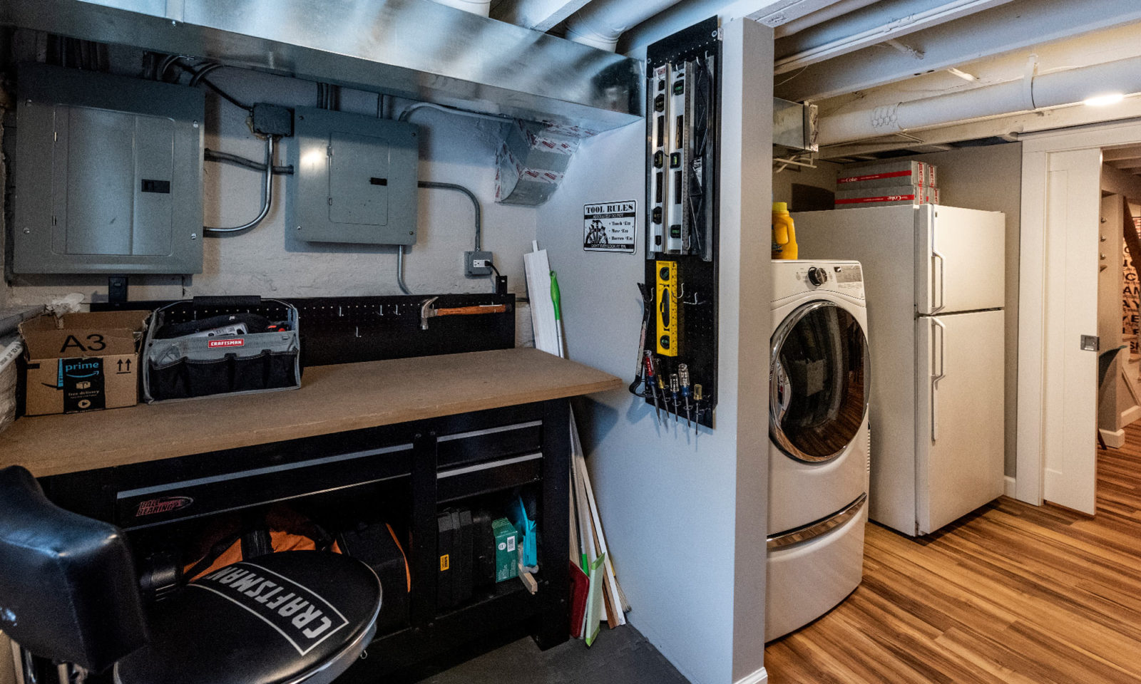 view of basement tool room and adjacent laundry