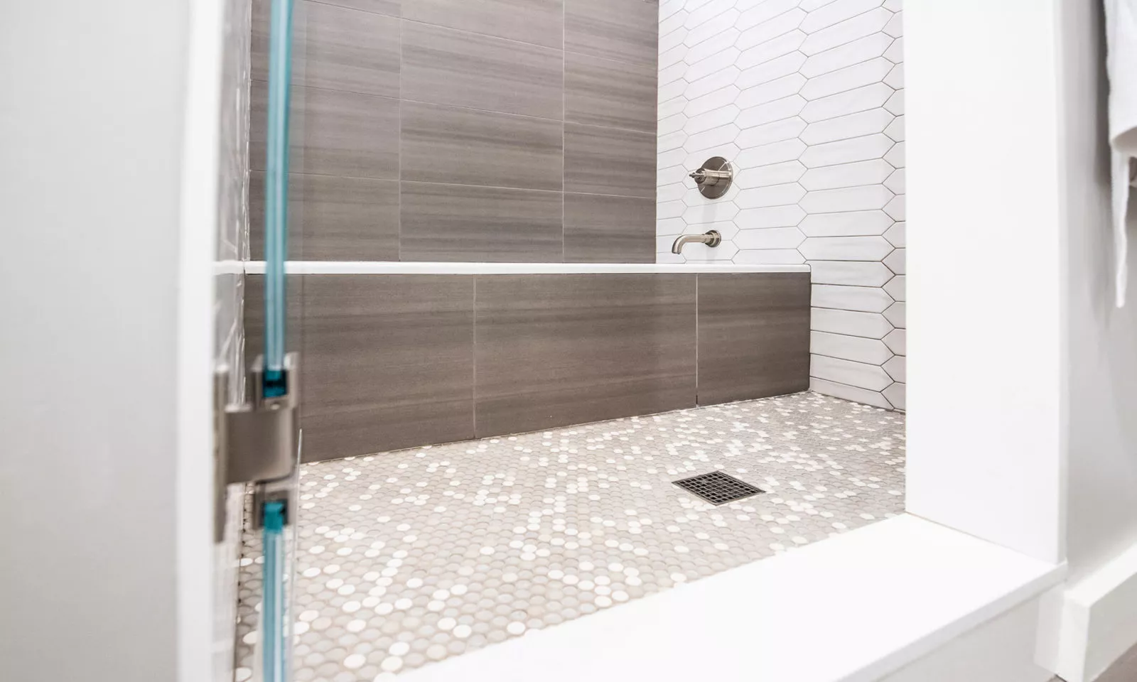 shower and tub with grey penny tile floor