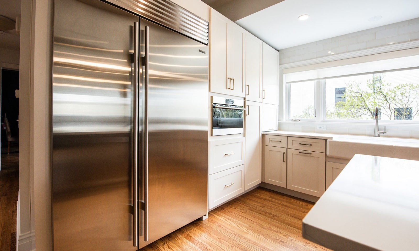 Stainless steel fridge next to cream cabinets in newly renovated kitchen