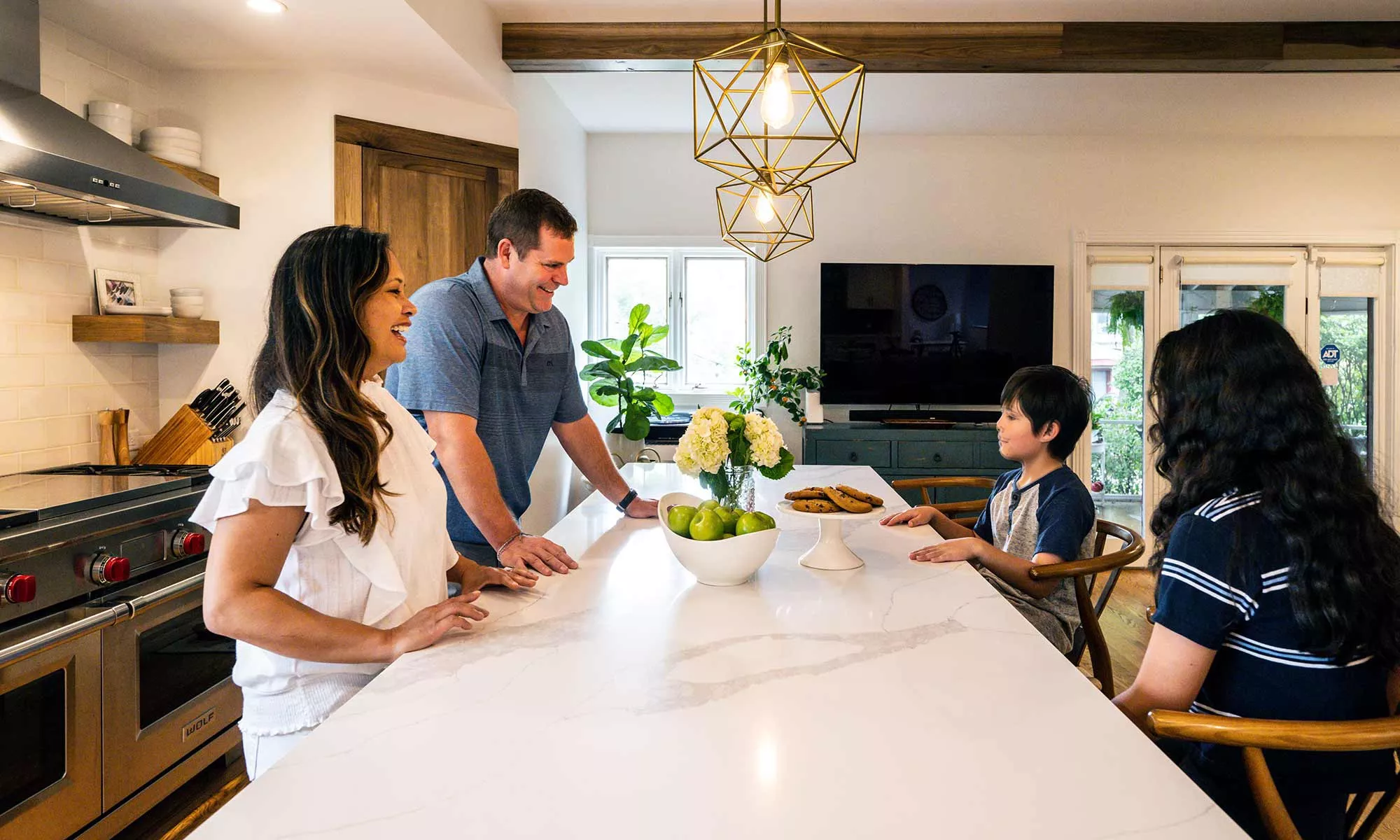 family around luxury kitchen island with dog