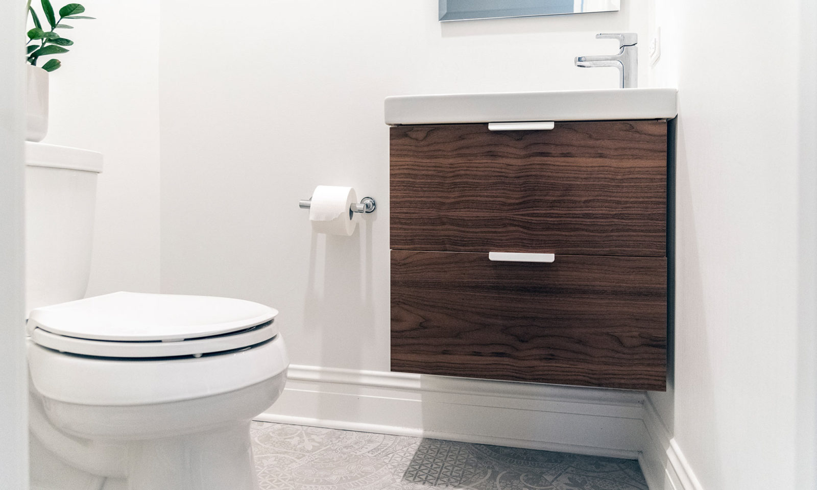 Newly renovated bathroom with white walls and flooring and dark wooden sink cabinet