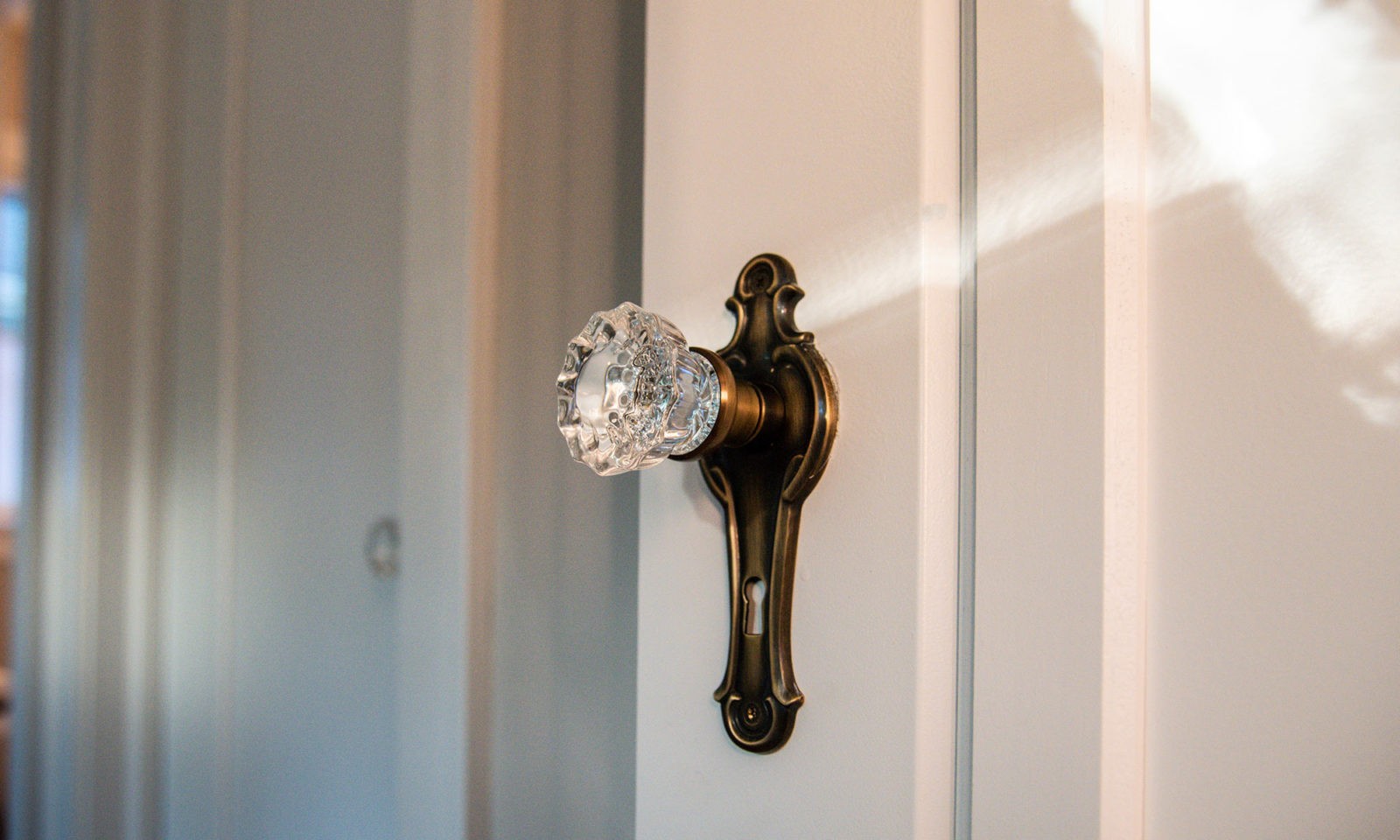 Glass door knob in intricate vintage-style gold door knob holder