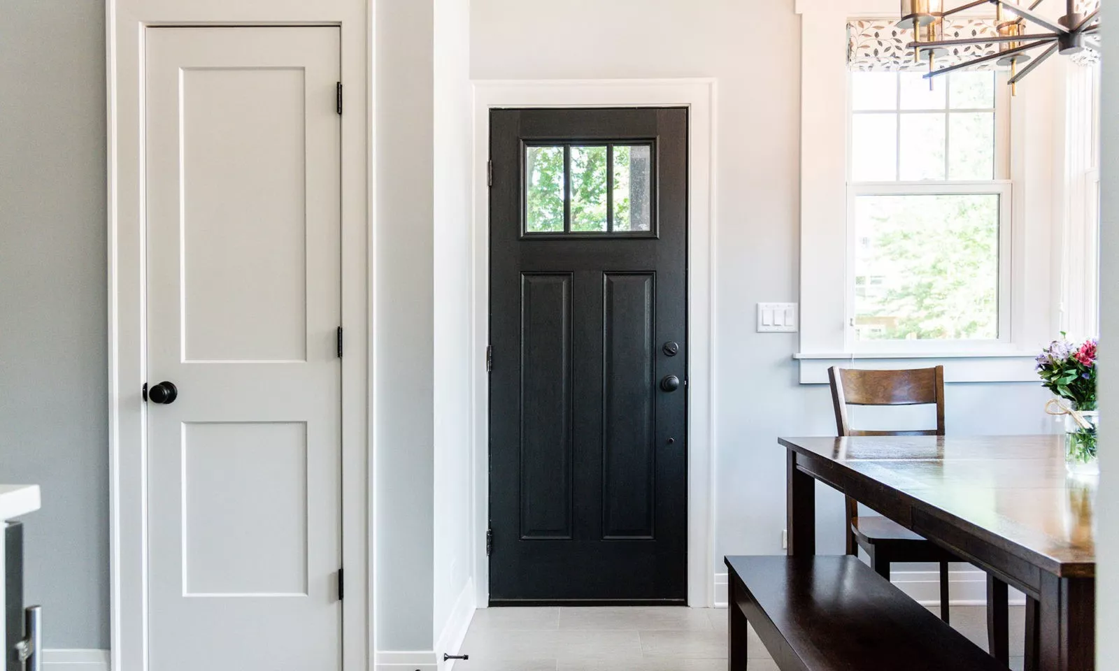 Newly renovated kitchen with statement dark kitchen door against light color walls