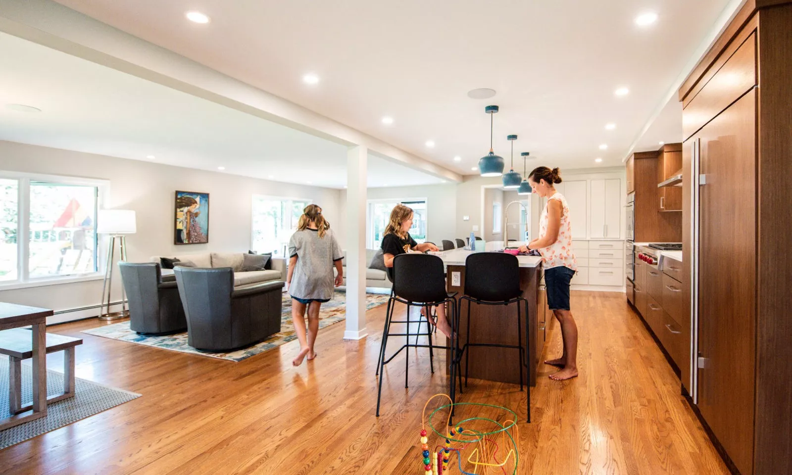 family in a modern hinsdale kitchen remodel with white counters and blue pendant lights