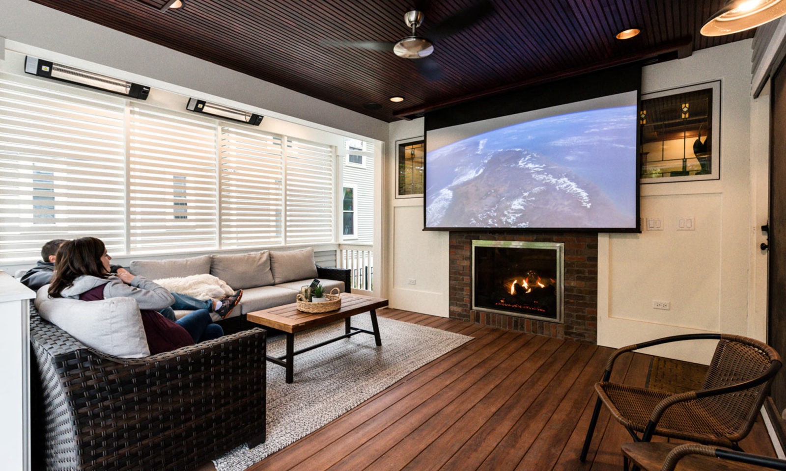 family sitting on couch watching tv on back porch addition