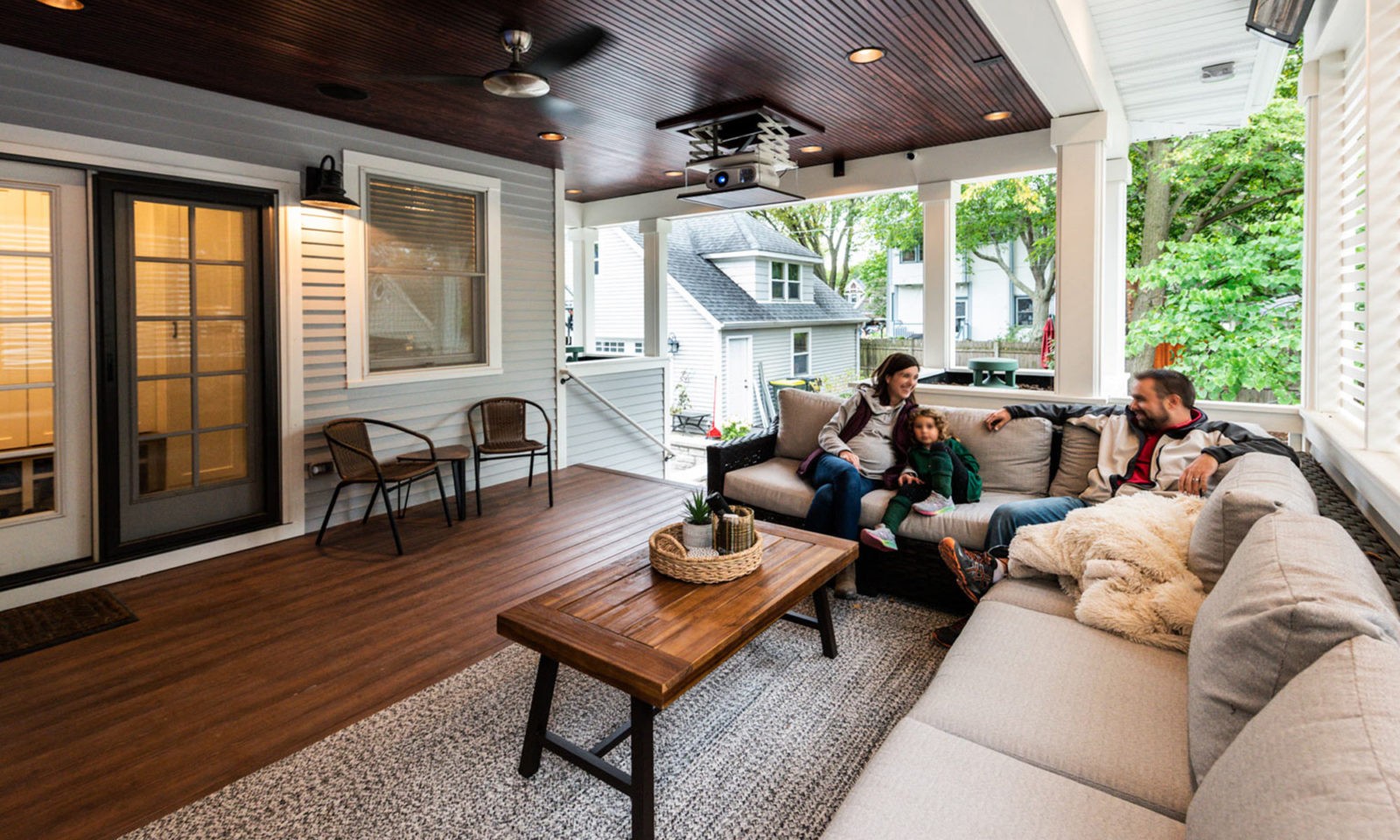 family sitting on couch on back porch addition