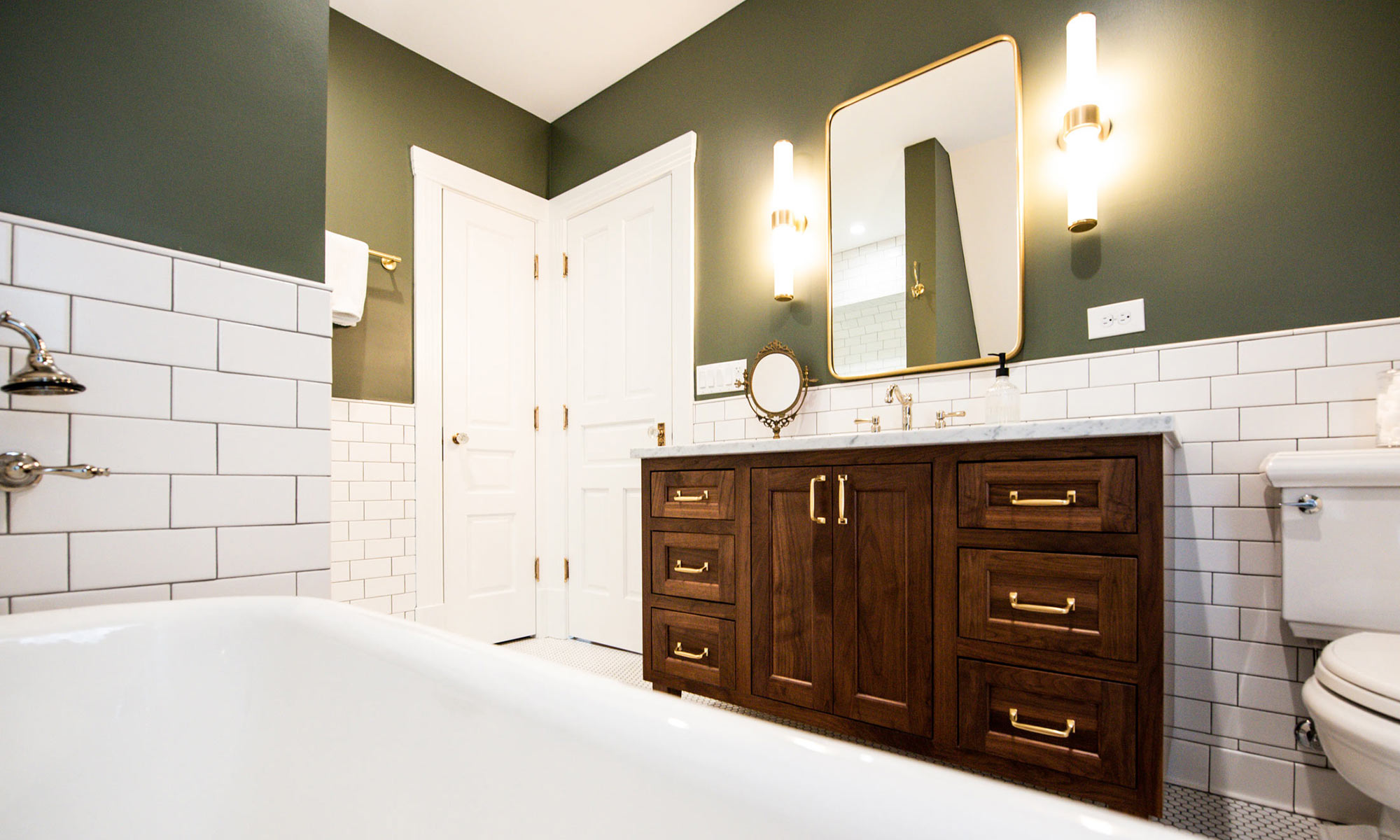 luxury bathroom with walnut vanity and gold fixtures