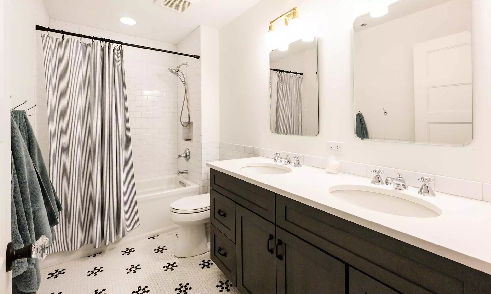bathroom remodel with grey double vanity and white black hex tile