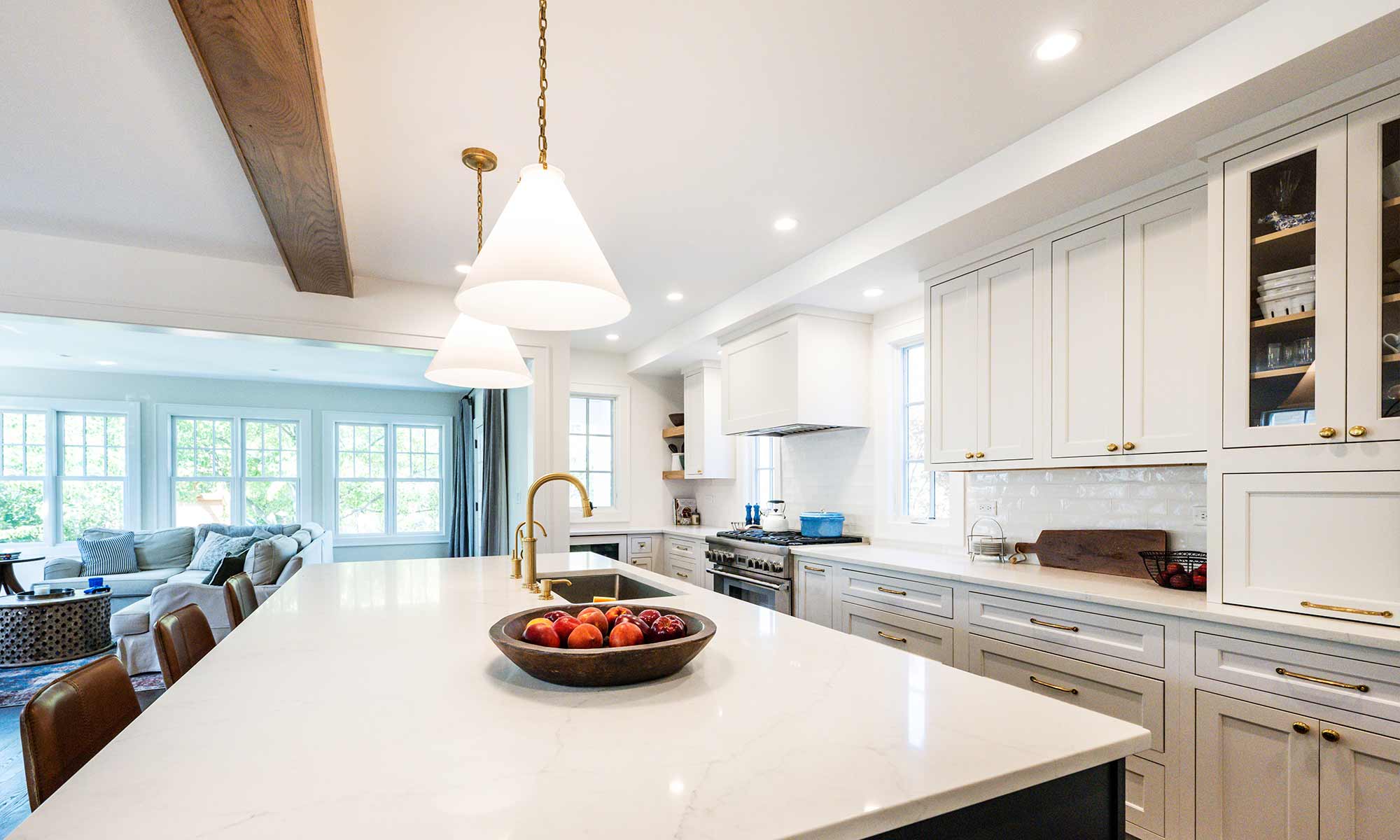 Luxury remodel and kitchen island with white and blue cabinets and white quartz countertops