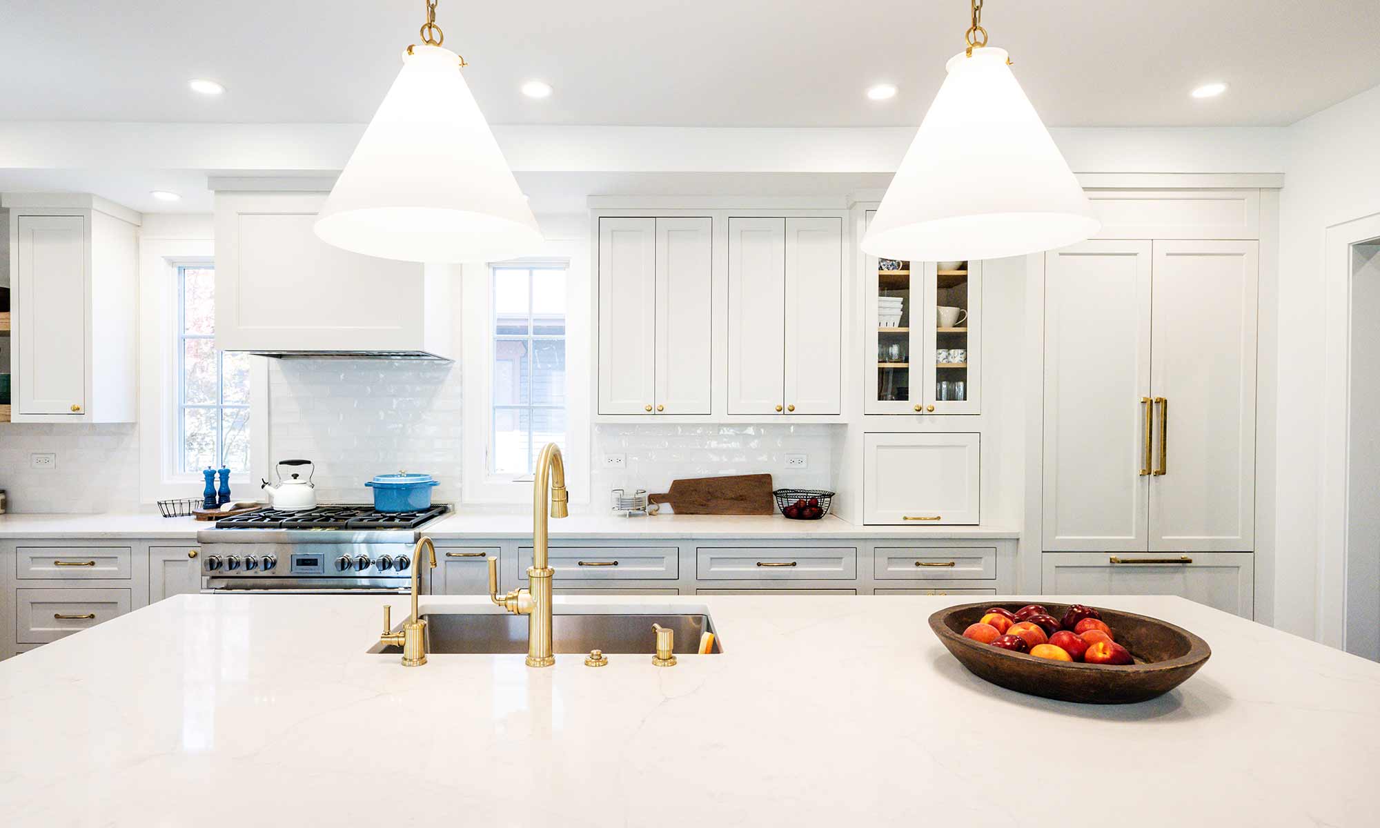 Luxury remodel and kitchen island with white and blue cabinets and white quartz countertops