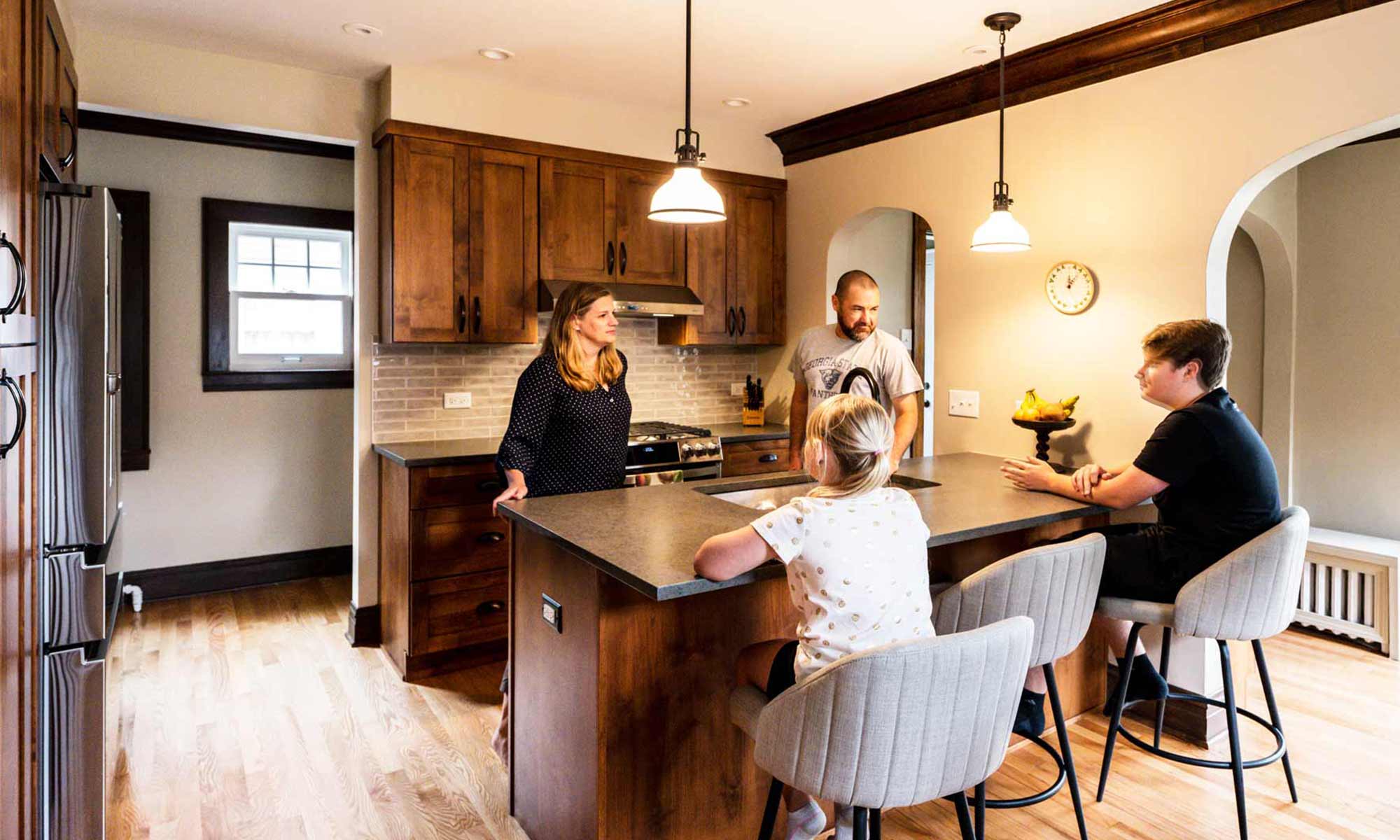 Family gathered in newly remodeled kitchen with dark wood cabinets
