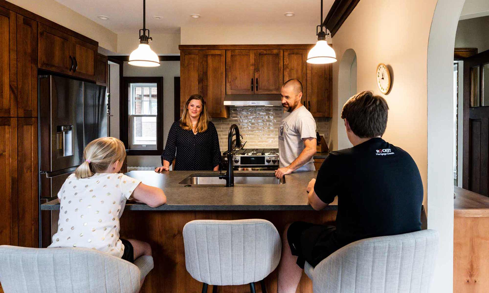 Family gathered in newly remodeled kitchen with dark wood cabinets