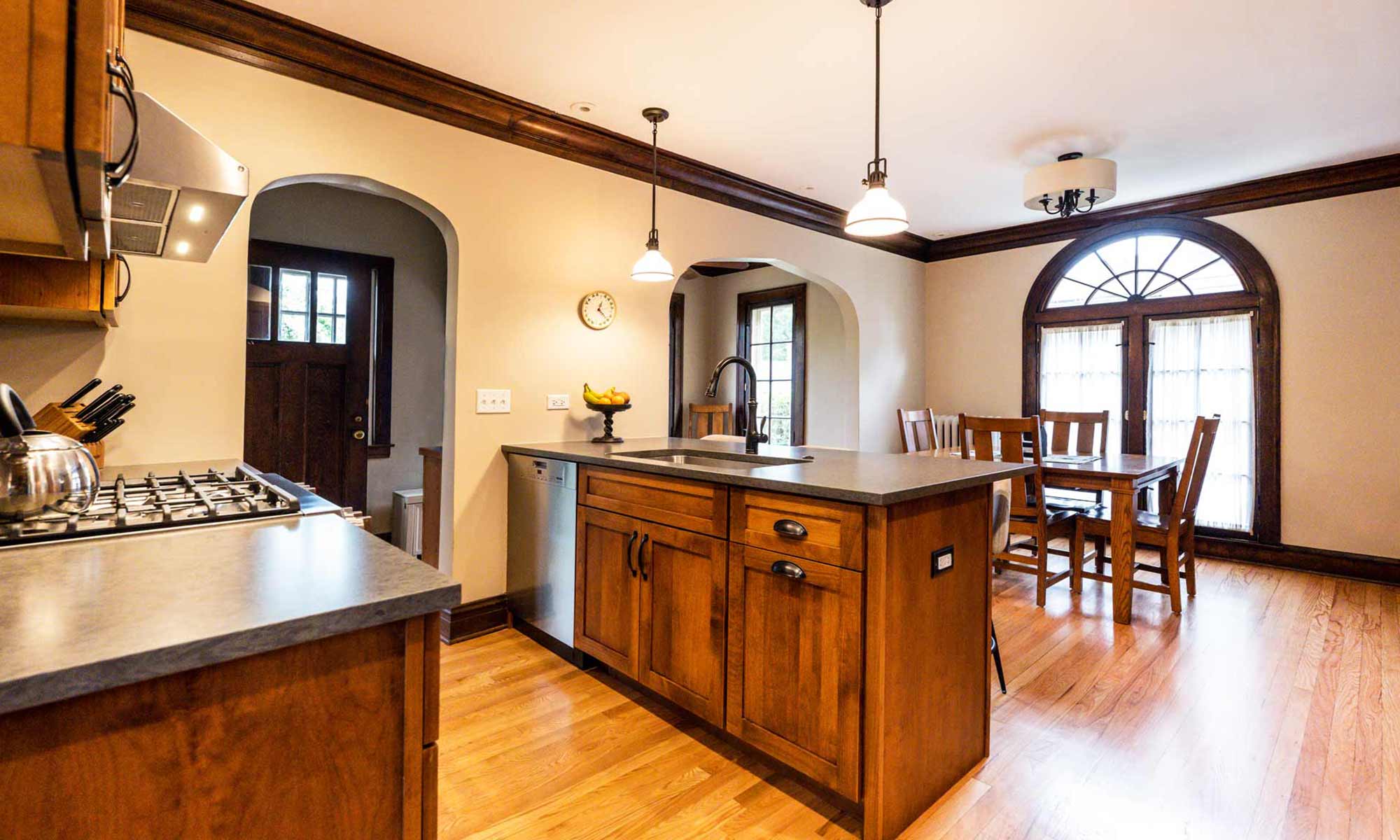 dark wood kitchen cabinets with peninsula seating and tall pantry cabinets