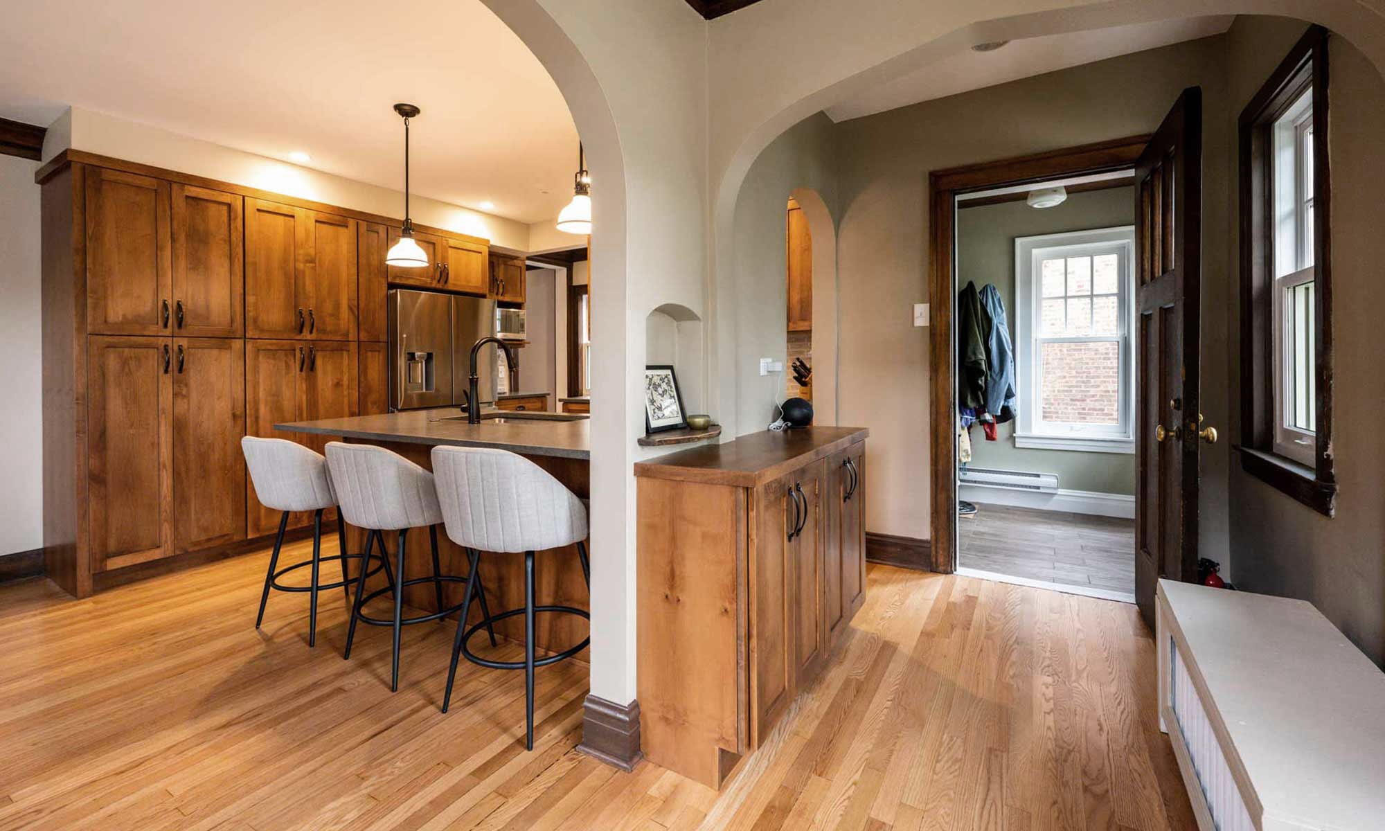 dark wood kitchen cabinets with peninsula seating and tall pantry cabinets