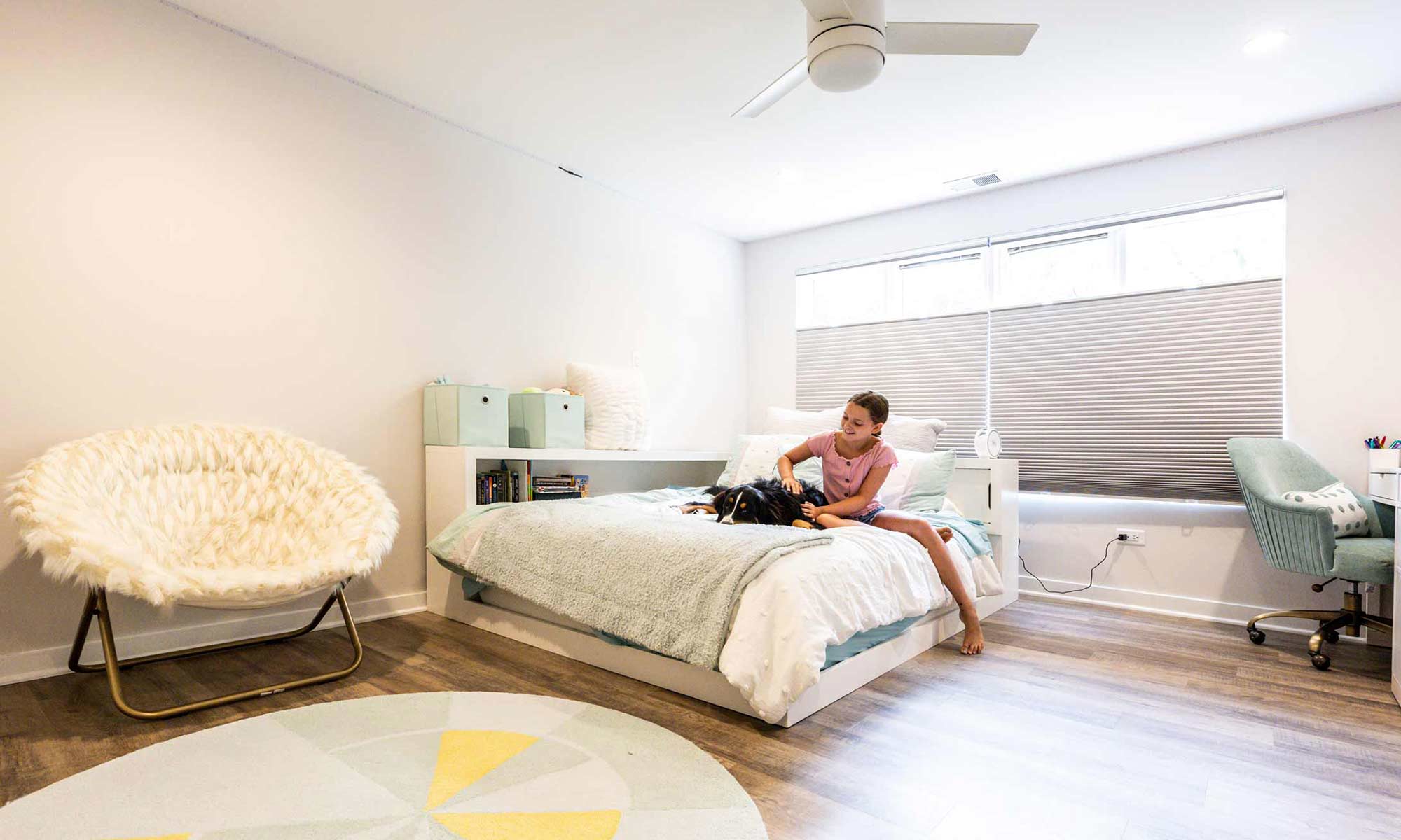 girl sitting on bed in remodeled kids bedroom